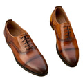 Pair of Louis Vuitton men's brown leather Oxford dress shoes with Monogram Flower details shoes on a white background